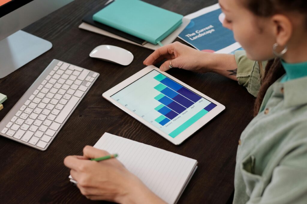 Woman reviewing digital graphs on tablet in an indoor workspace. Perfect for business and technology themes.